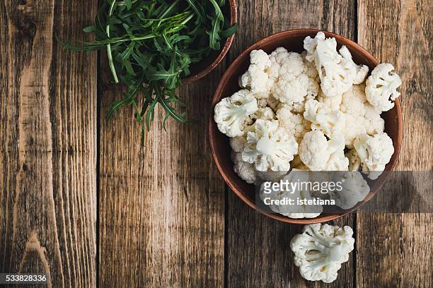 fresh organic cauliflower cut into small pieces in a bowl. vegetarian recipe or menu background with copy space - crucíferas - fotografias e filmes do acervo