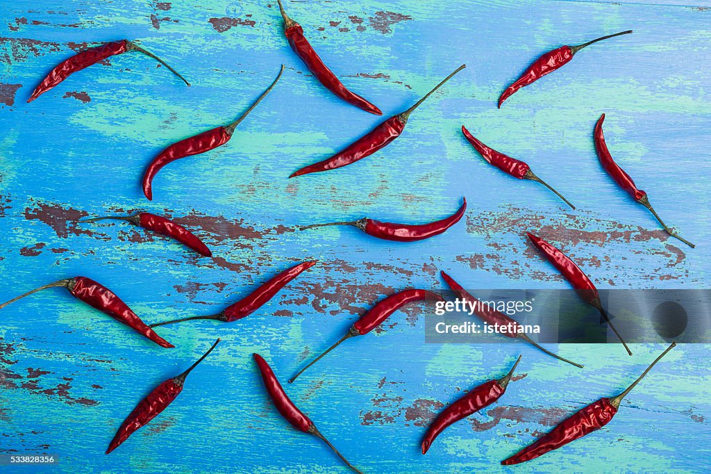 Red hot chili peppers on rustic blue wooden board, overhead view