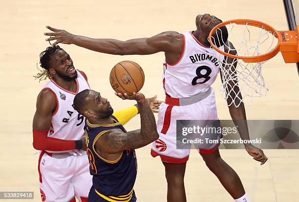 LeBron James of the Cleveland Cavaliers drives to the basket against Bismack Biyombo and DeMarre Carroll of the Toronto Raptors in the first half in...