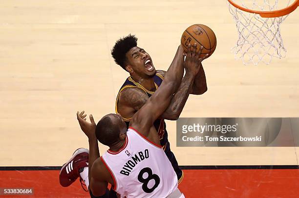 Iman Shumpert of the Cleveland Cavaliers drives to the basket in the first half and is fouled by Bismack Biyombo of the Toronto Raptors in game four...