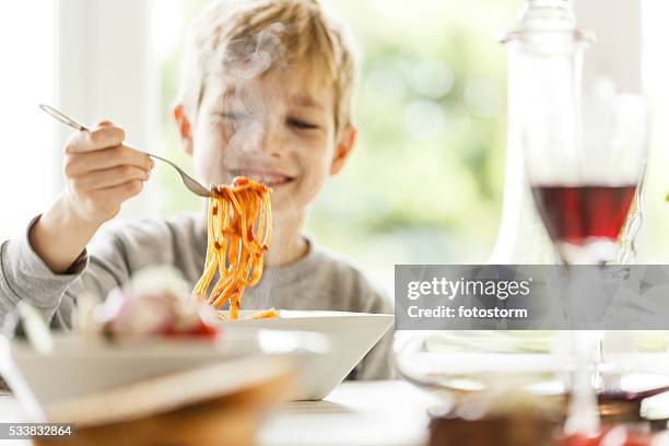 boy eating spaghetti - restaurant kids stock pictures, royalty-free photos & images