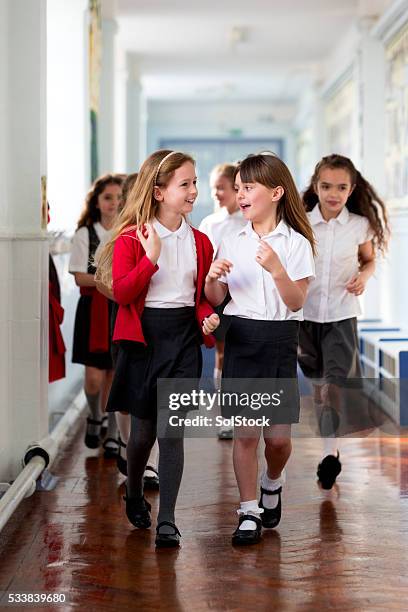 schulmädchen zur schule - school uniforms stock-fotos und bilder