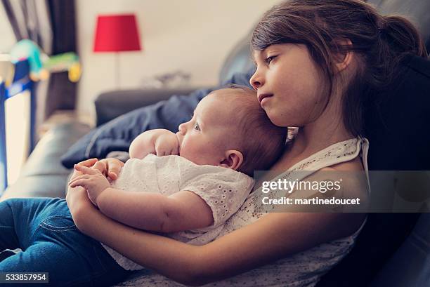 schläfrig mädchen holding baby-schwester auf der couch zu hause fühlen. - 7 stock-fotos und bilder