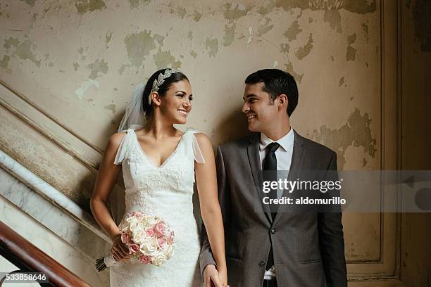 hispanic newlyweds standing against a grunge wall - couple passion stock pictures, royalty-free photos & images