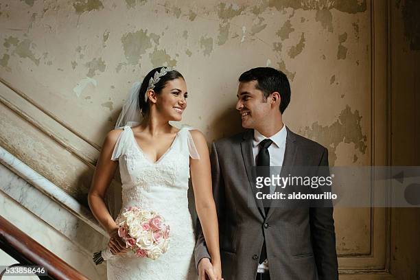 hispanic newlyweds standing against a grunge wall - 新婚夫婦 個照片及圖片檔