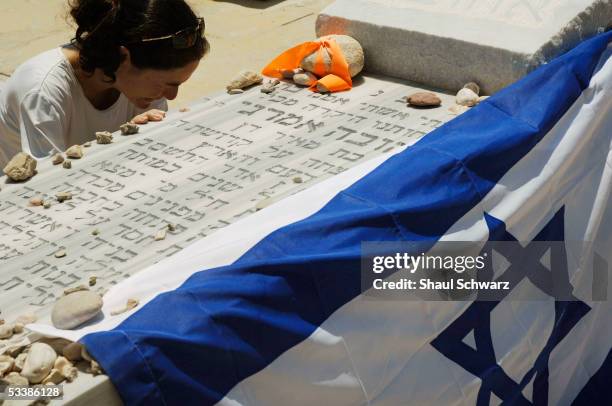 An Israeli settler prays at a relative's grave August 14, 2005 at the regional cemetery at Neve Dekalim in the Gaza Strip. Hundreds of residents of...