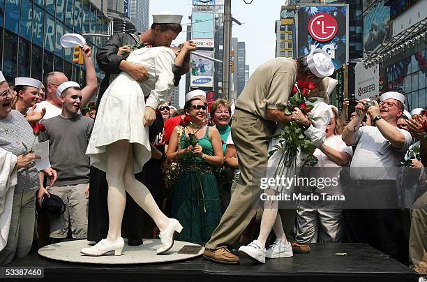 Carl Muscarello and Edith Shain, who claim to be the nurse and sailor in the famous photograph taken on V-J Day, kiss next to a sculpture based on...