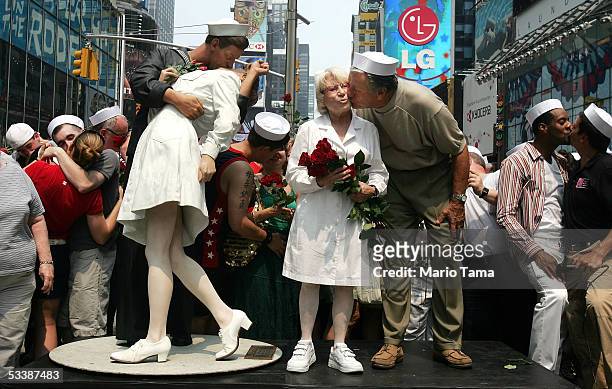 Carl Muscarello and Edith Shain, who claim to be the nurse and sailor in the famous photograph taken on V-J Day, kiss next to a sculpture based on...