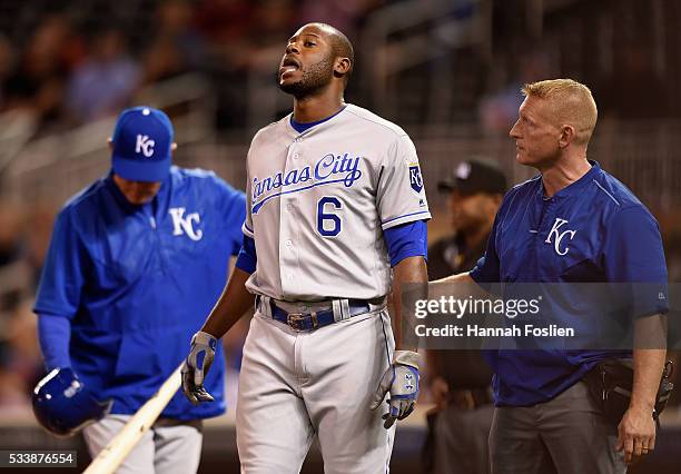 Manager Ned Yost and trainer Nick Kenney of the Kansas City Royals check on Lorenzo Cain after fouling off a pitch on his leg during the fourth...