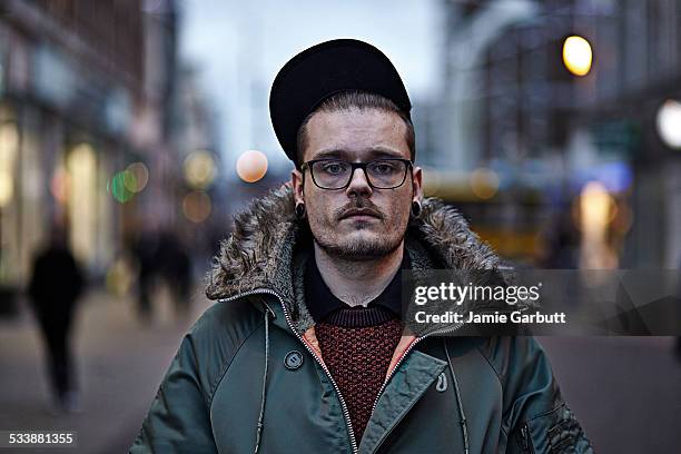 mid 20's male stood in town centre - centre de spectacles stockfoto's en -beelden