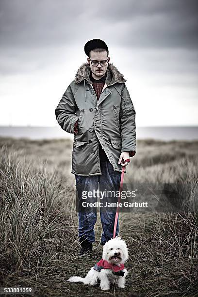 portrait of mid 20's male and his dog - chinese crested powderpuff stock pictures, royalty-free photos & images