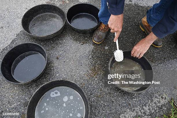 Fred Horak cleans food containers at his property on Wednesday May 11, 2016 in Gettysburg, PA. Ever since he and his wife, Joan Horak noticed...