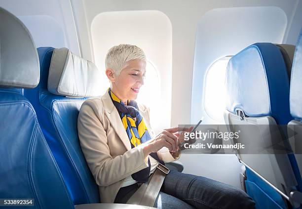 business woman at airplane - vehicle seat stock pictures, royalty-free photos & images