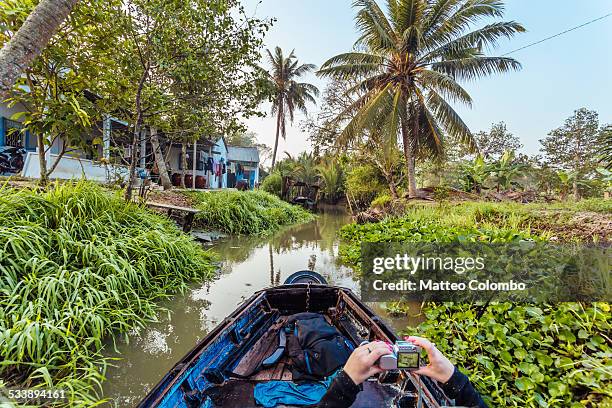 Woman taking a photo while canoeing in Vietnam