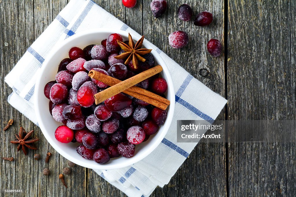 Frozen cranberries with spices background