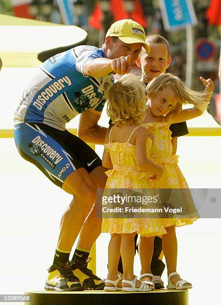 Lance Armstrong of the USA riding for the Discovery Channel cycling team with his children Luke, Grace and Isabella on the podium after stage 21 of...