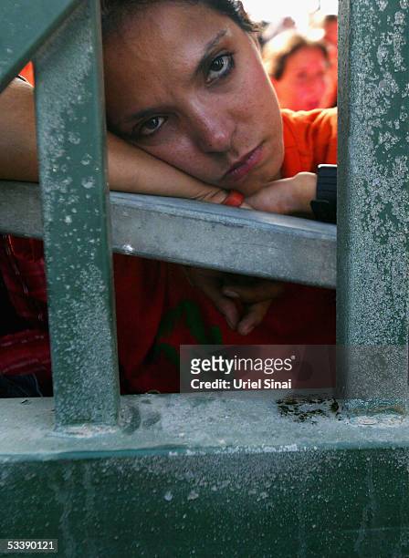 An opponent of the disengagement plan stands behind the locked gates, August 15, 2005 in the Israeli settlement of Neve Dekalim in southern Gaza...