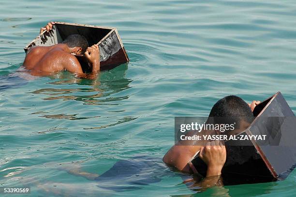 Kuwaiti divers search for pearls in shells they picked during the pearl diving festival in the port of Khairan, 100 kms south of Kuwait City, 15...