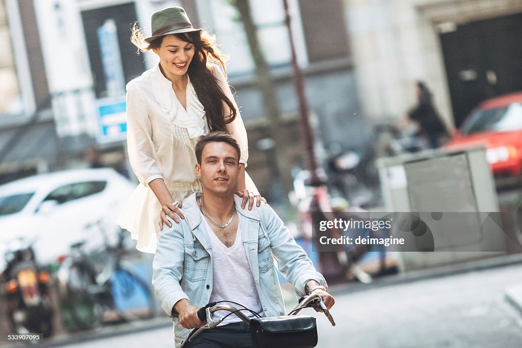 Young couple with bicycle through the city streets