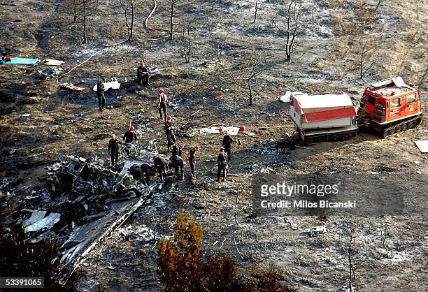Firefighters and rescue personnel search the debris of a Cypriot Helios Airways passenger jet the day after the plane crashed on a hillside August...