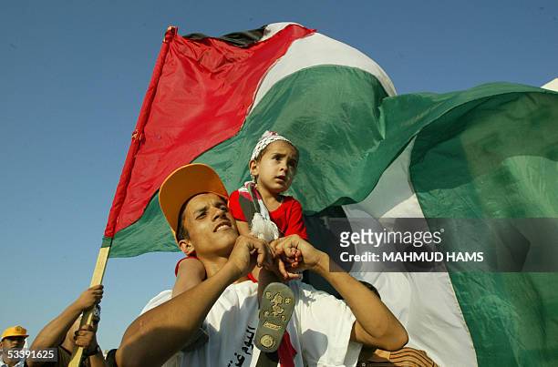 Palestinain youth carries his sister during a celebration rally in Gaza city 15 August 2005, as Israel began its historic pull out operation from the...