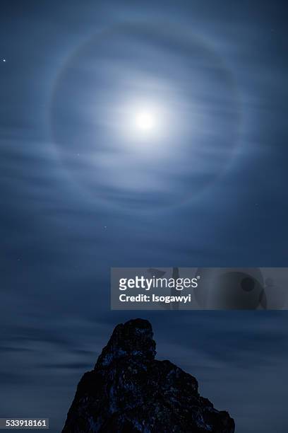 a lunar halo above the rocks - isogawyi stockfoto's en -beelden