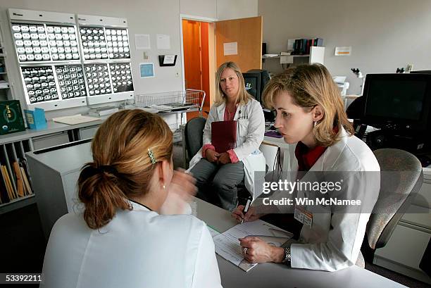 Dr. Julie Brahmer and Katie Thornton review the results of PET scans , shown in background, of a patient being treated at the Kimmel Comprehensive...