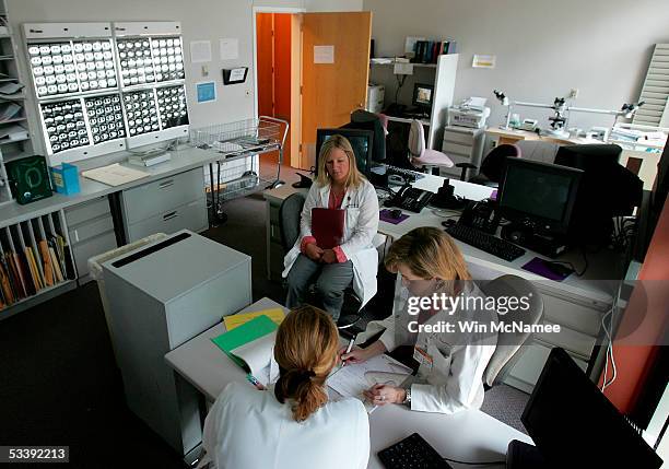 Dr. Julie Brahmer and Katie Thornton review the results of PET scans , shown in background, of a patient being treated at the Kimmel Comprehensive...