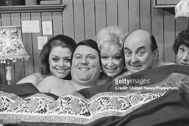 Actors Lynda Baron, Terry Scott, June Whitfield and Dennis Ramsden pictured together in a bed on stage at the Victoria Palace Theatre in London...