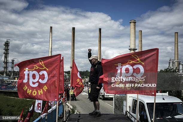 Striking worker stands next to French CGT union flags in front of the Total oil refinery of Feyzin, near Lyon, central-eastern France, on May 24...