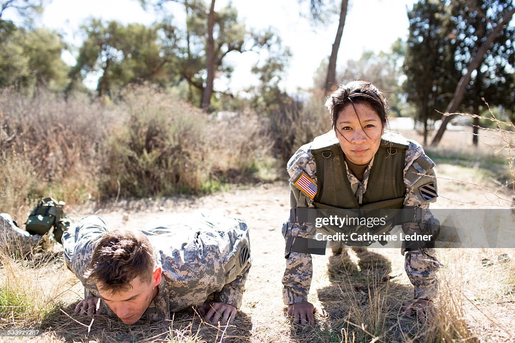 Army woman and man doing pushups