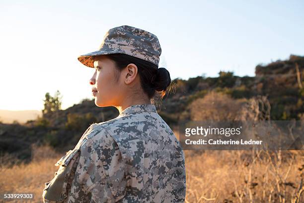 portrait of army woman at sunset - armed forces stock-fotos und bilder