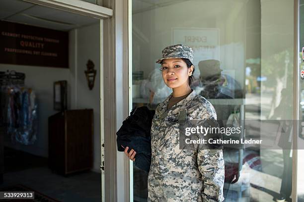 army woman bringing laudry to dry cleaners - army soldier portrait stock pictures, royalty-free photos & images