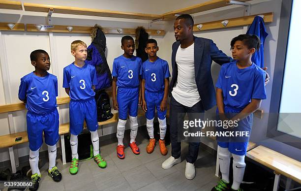 France's defender Patrice Evra speaks with young players before a football match in Les Ulis on May 23, 2016. France's defender Patrice Evra and...
