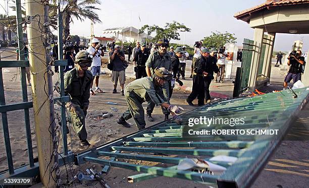 Israeli soldiers push down the main gate of the southern Gaza Strip settlement of Neve Dekalim after cutting through it early 16 August 2005. Israeli...