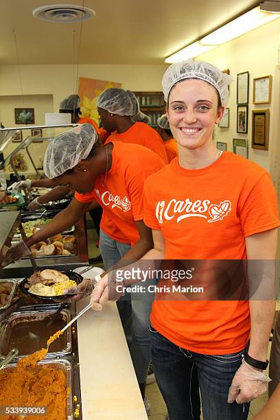 Kelly Faris of the Connecticut Sun participates at a WNBA Cares event and serves food at the New London Community Meal Center on May 23, 2016 in New...