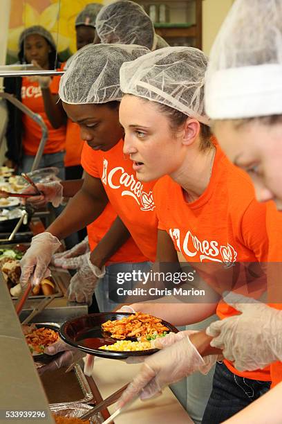 Kelly Faris of the Connecticut Sun particiate at a WNBA Cares event and serves food at the New London Community Meal Center on May 23, 2016 in New...