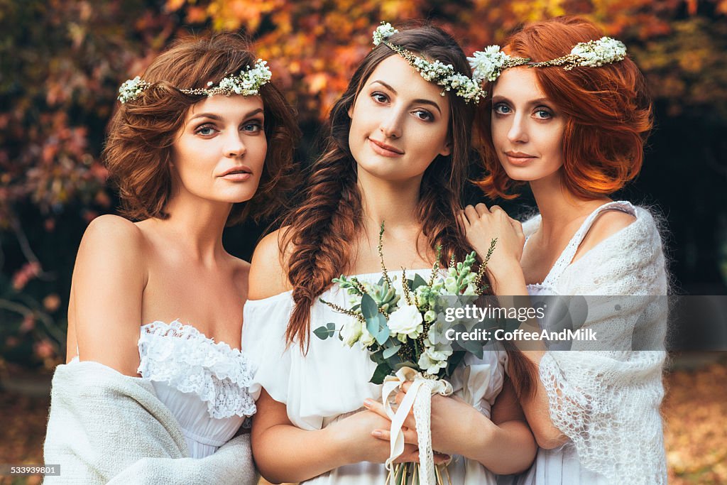 Three beautiful bride on a background of autumn forest