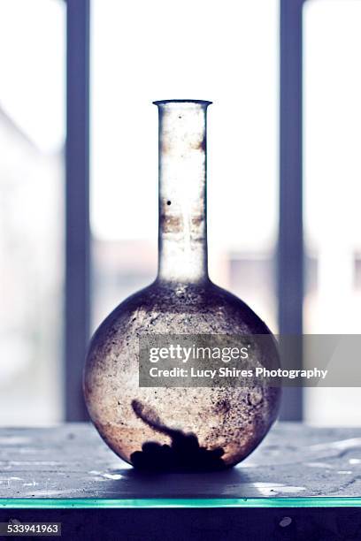 dirty flat bottomed glass flask - lucy shires stockfoto's en -beelden