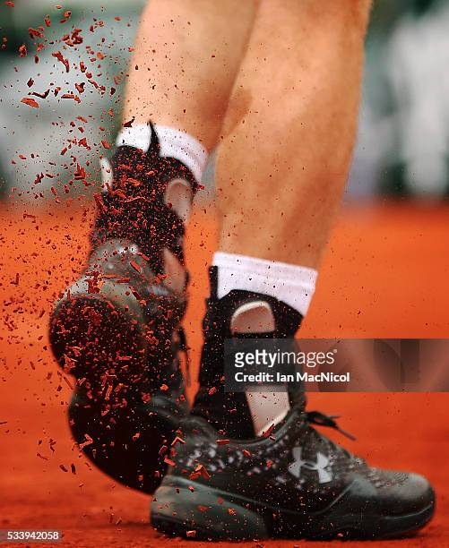 Andy Murray of Great Britain knocks the clay from the sole of his shoe during the Men's Singles first round match against Radek Stepanek of the Czech...