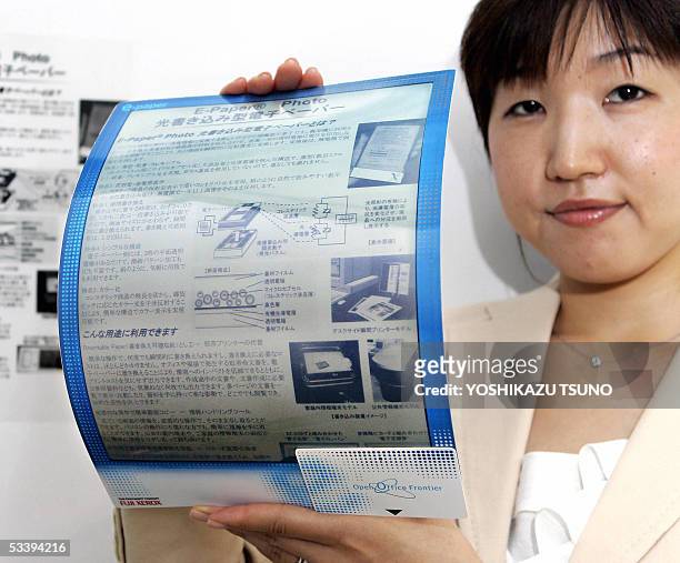 Employee for Japanese electronics giant Fuji Xerox, Naoko Okada, displays a prototype model of electronic paper called "E-Paper" which enables a user...