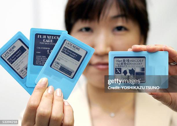 Employee for Japanese electronics giant Fuji Xerox, Naoko Okada, displays a prototype model of a card type electronic paper called "E-Paper Visual...