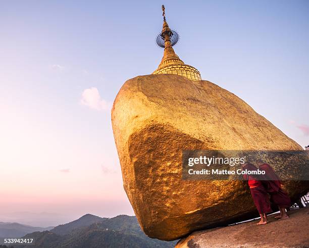 two buddhist monks praying at golden rock, myanmar - kyaiktiyo pagoda stock pictures, royalty-free photos & images