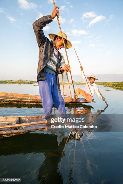 two intha fishermen fishing with harpoon - myanmar culture stockfoto's en -beelden