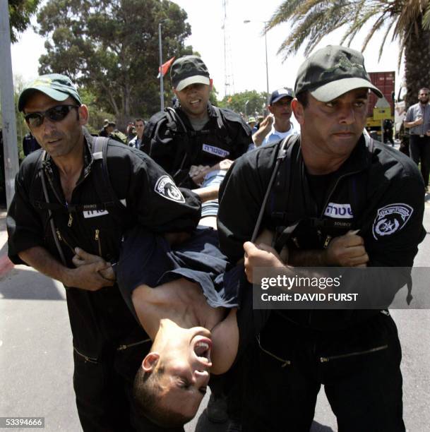 An Israeli settler is carried away by Israeli police officers after he and other protestors attempted to block the main road to the southern Gaza...