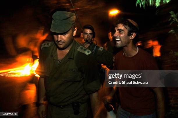 Settler screams at a solider as the Israeli army officers deliver the eviction notice to a Jewish settler late on August 16, 2005 in the Gaza Strip...