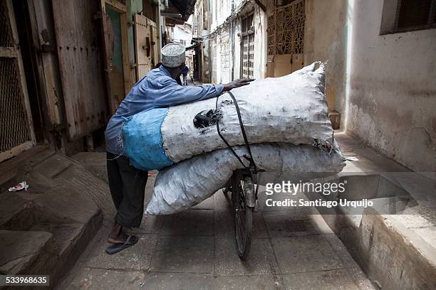 old man carrying huge sacks of coal on his bicycle - carbon cycle stockfoto's en -beelden