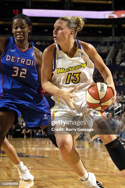 Penny Taylor of the Phoenix Mercury drives to the basket against Swin Cash of the Detroit Shock on August 16, 2005 at America West Arena in Phoenix,...