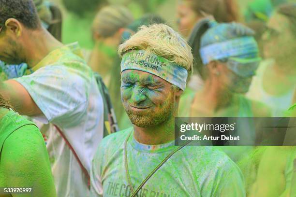 People covered with colorful Gulal powder during the Color Run, a race with party, music and colors in Barcelona city. Catalonia, Europe.