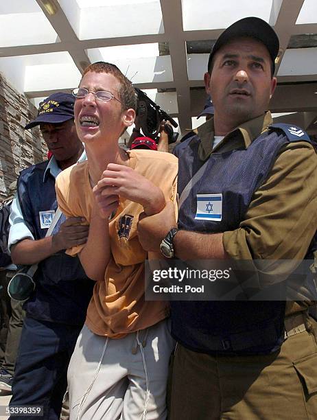 An Israeli settler shouts at Israeli soldiers as he is taken away of the Synagogue August 17, 2005 in the southern Gaza Strip settlement of Morag....